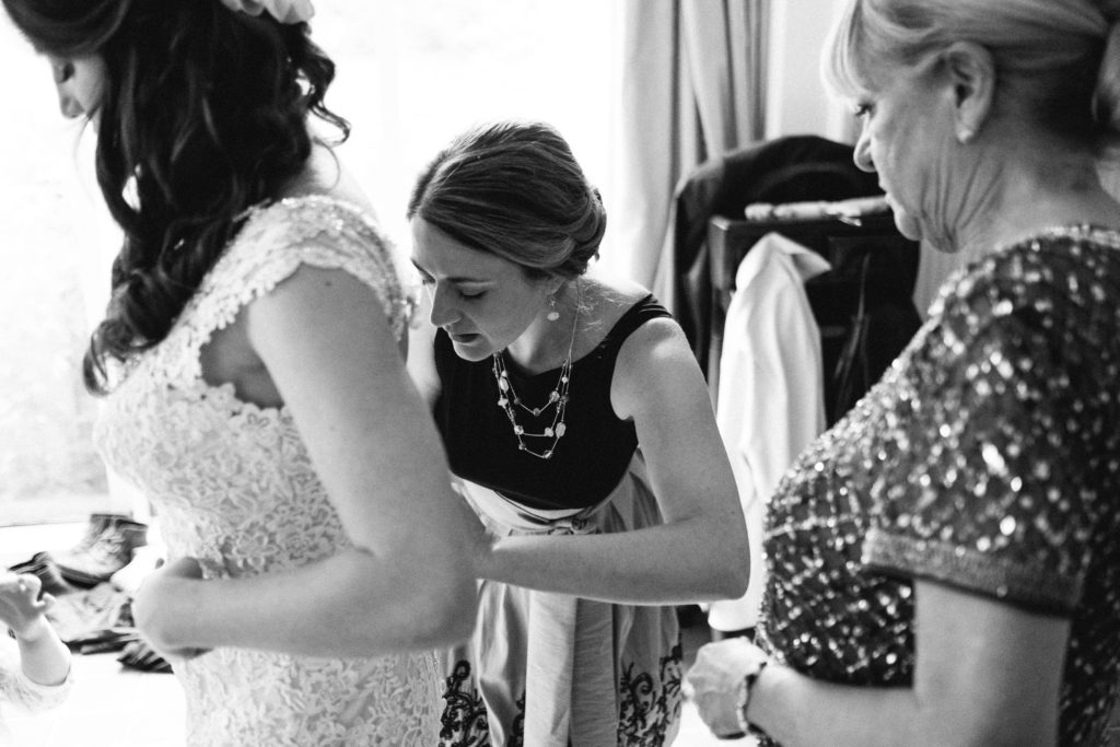 bride havving her dress clipped up at the back 