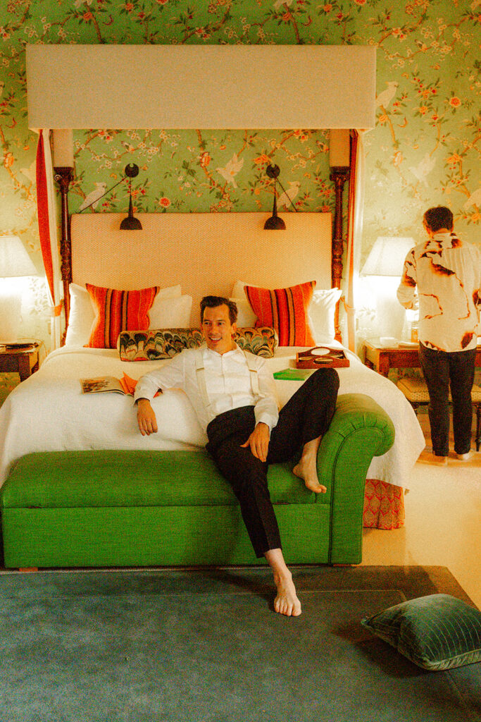 Groom sitting laying on bed with no socks on befroe the his big day