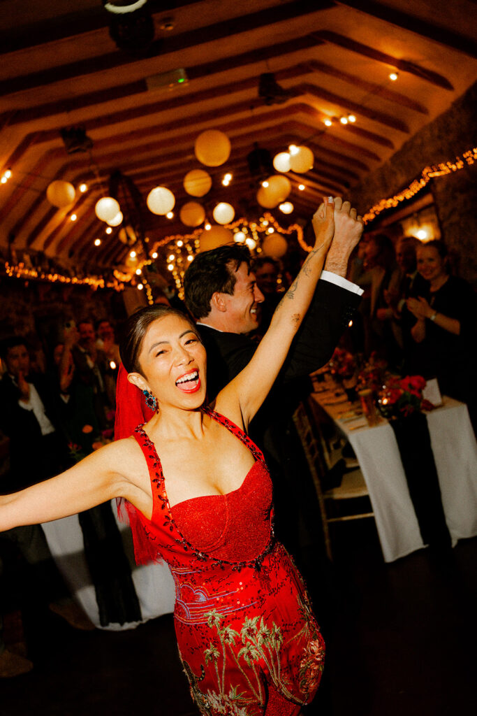 bride in red dress partying with her groom in a bar in county clare