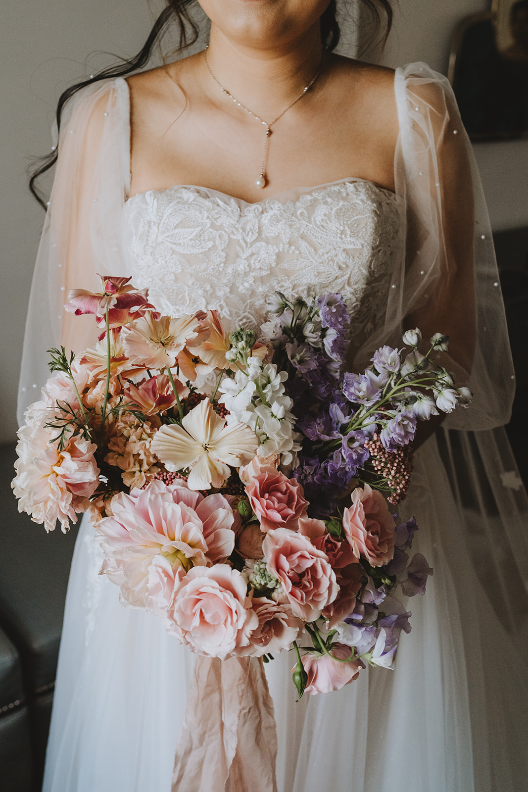 the bride with her bouquet of soft lavenders and peach colred bouquet with hints of lilac