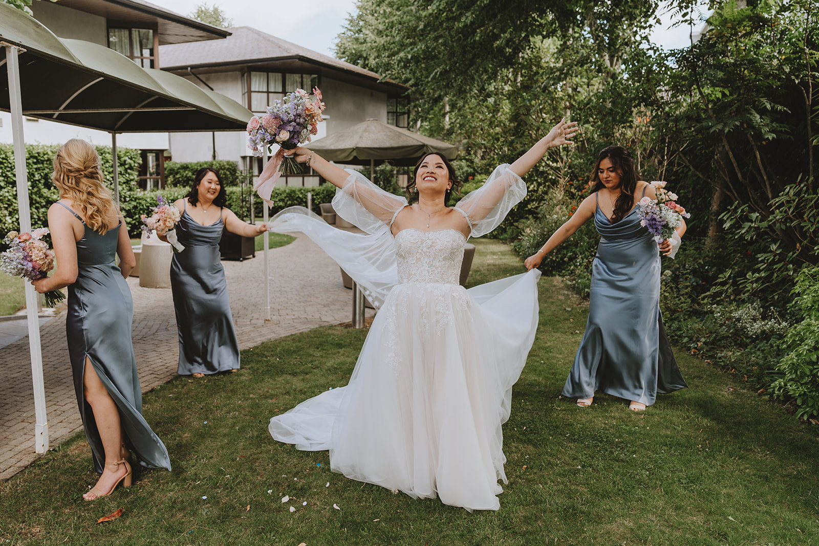 the getting rady to bouquet and here bridesmaids holding her wedding dress