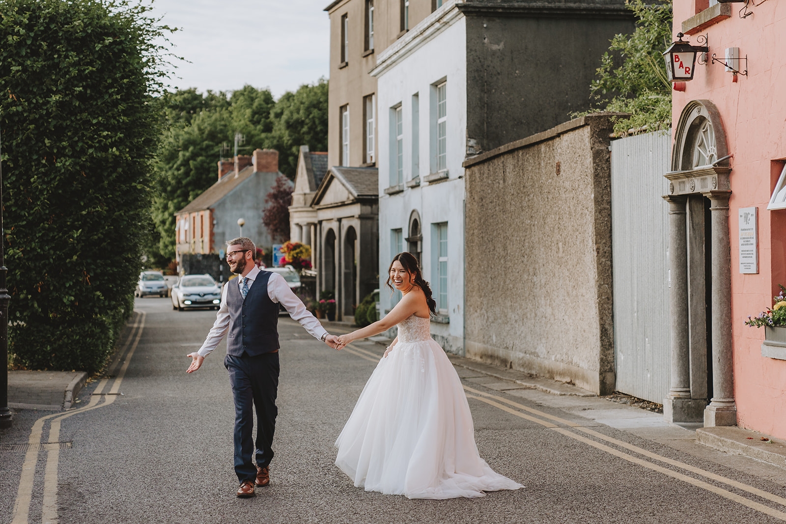 Kam and ryan walking down the town street in kilkenney holding hands and smiling